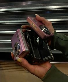 a person holding two cameras in their hands