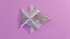 an origami fish made out of money on a pink background with the words,