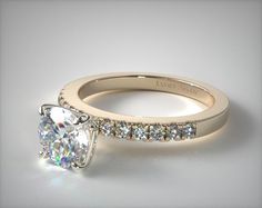 an engagement ring with a princess cut diamond in the center and side stones on the band