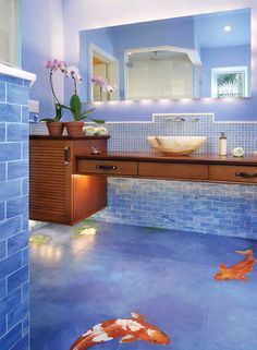 a blue tiled bathroom with two koi fish on the floor