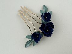 This stunning gold wedding hair comb is adorned with handcrafted polymer navy blue flowers. The rich navy blooms and sage green foliage create a beautiful contrast, adding a touch of elegance and sophistication to any bridal hairstyle. Style: Elise  W: 3.25" (8.3 cm) H: 3" (7.6 cm)  Due to the handcrafted nature, slight variations may be present between pieces, adding to their charm and individuality. These small differences make each piece truly unique. Sage Green Leaves, Gold Hair Comb Wedding, Navy Blue Flowers, Blue Clay, Wedding Hair Comb, Clay Flower, Wedding Hair Pins, Navy Wedding, Hair Comb Wedding