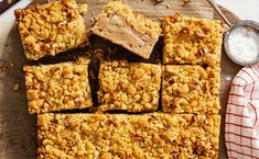 a wooden cutting board topped with squares of food