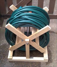 a large green hose sitting on top of a wooden stand