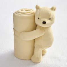 a stuffed bear holding onto a roll of toilet paper