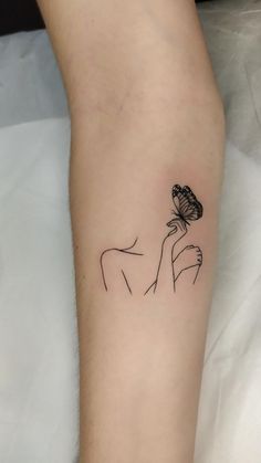 a woman's arm with a butterfly tattoo on the left side of her leg