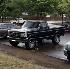 several trucks parked in a parking lot on a rainy day