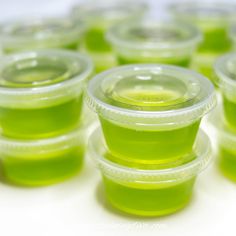 several plastic cups with green liquid in them