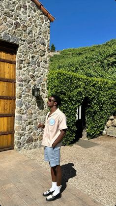 a man standing in front of a stone building