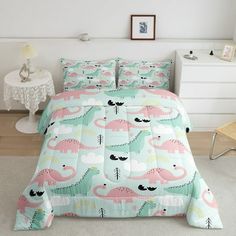 a bed room with a neatly made bed covered in pink and green dinosaur bedspreads