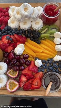 a tray filled with fruit and dips on top of a table