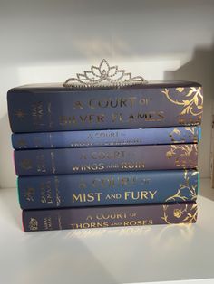 a stack of five books sitting on top of a white table next to a book shelf