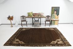 a room with two chairs and a rug on the floor in front of a table