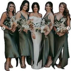 a group of women standing next to each other wearing dresses and holding bouquets in their hands