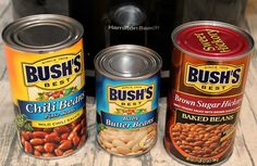 three cans of food sitting on top of a wooden table