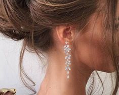 a close up of a woman's face wearing earrings with flowers on them,