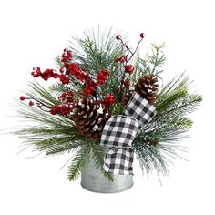 a christmas arrangement with pine cones and berries in a galvanie bucket on a white background