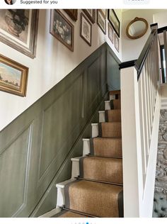 a staircase with pictures on the wall and carpeted steps leading up to an upstairs landing