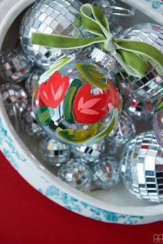 a bowl filled with christmas ornaments on top of a table