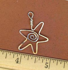 a metal keychain with a star on it and a measuring tape in the background