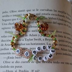 an open book with beads and charms on it's pages that spell out words