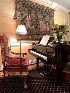 a grand piano sitting in front of a tapestry