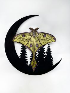 a yellow moth sitting on top of a crescent shaped wall clock with trees in the background