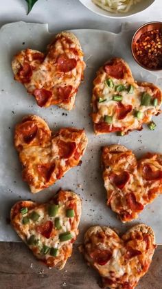 heart shaped pizzas on a cutting board with toppings