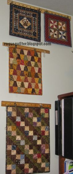 three quilts are hanging on the wall next to each other