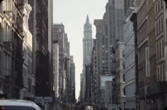 a city street filled with tall buildings and cars driving down the road next to each other