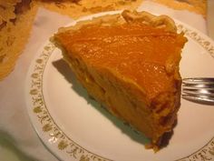 a slice of pumpkin pie on a plate with a fork