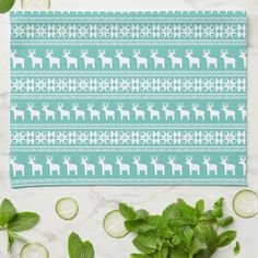 a towel with an image of a deer and cucumbers on it, surrounded by mint leaves