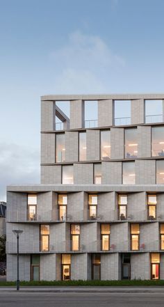 an apartment building with many windows and balconies on the top floor is lit up at night