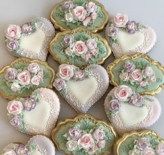 there are many decorated cookies in the shape of hearts and roses on this white table