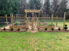 a garden area with several wooden planters and fenced in areas around the yard