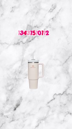 a white coffee cup sitting on top of a marble counter next to a pink sign