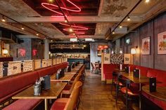 an empty restaurant with red booths and wooden tables