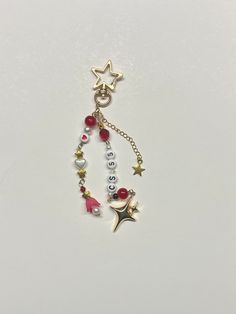 a necklace with beads and charms hanging from it's side on a white surface