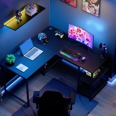 a computer desk with two monitors and a keyboard on it in a room that has blue walls