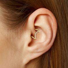 a woman's ear is shown with a single diamond in the middle and an open one behind it