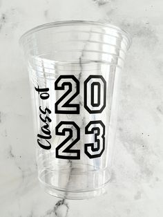 a clear plastic cup with the numbers twenty two and twenty three printed in black on it