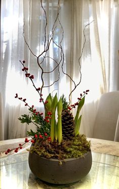 a table with a vase filled with flowers and plants