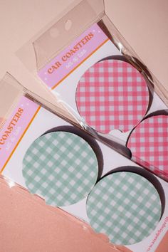 two pink and green gingham paper circles with scissors in front of each one