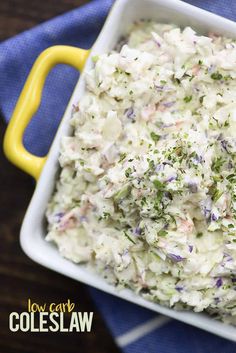 a white bowl filled with coleslaw on top of a blue and yellow towel