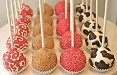 there are many different types of cake pops on the plate with white and red frosting