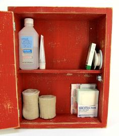 an old red cabinet with toiletries and hand sanitizers in it on the shelf