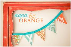 an orange frame with colorful flags hanging from it's sides and the words aqua & orange on top