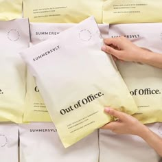 a woman is holding up some bags of office supplies that are stacked on top of each other