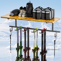 skis and snowboards are hanging on a rack in front of an ice - covered mountain