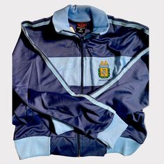 Premium Argentina Football Jacket Vintage Blue Track Jacket With Pockets, Blue Fitted Sporty Windbreaker, Vintage Blue Outerwear For Sports, Retro Blue Hooded Track Jacket, Vintage Blue Track Jacket For Winter, Blue Long Sleeve Sport Coat, Vintage Blue Long Sleeve Track Jacket, Fitted Blue Windbreaker For Winter, Blue Fitted Casual Windbreaker