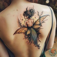 the back of a woman's shoulder with a tattoo of a fairy on it